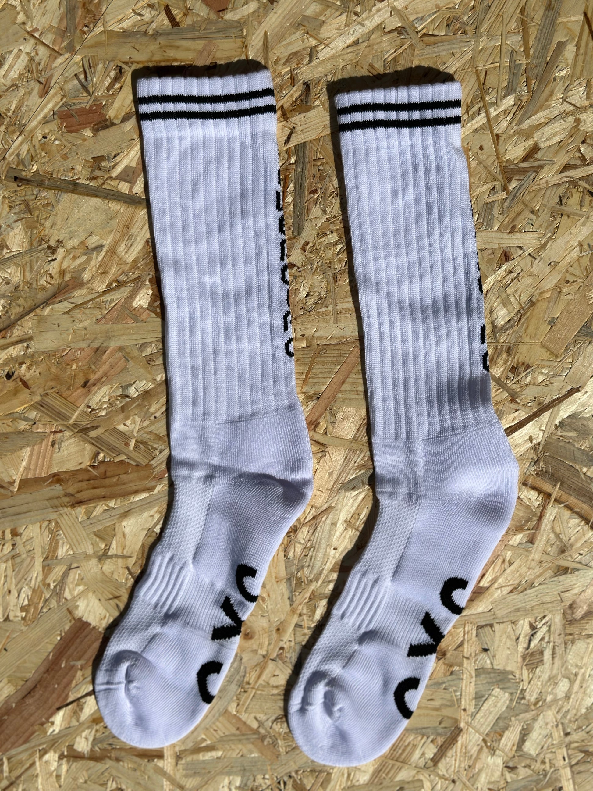 Pair of white Powerciao socks with black stripes and "CIAO" lettering, ready to support your feet through every jog, jump, and casual stroll with style and breathability.